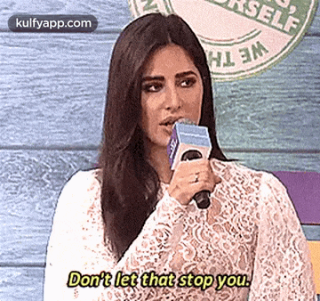 a woman is holding a microphone and talking into it .