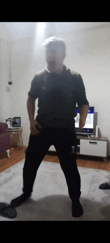 a man is standing in a living room in front of a tv