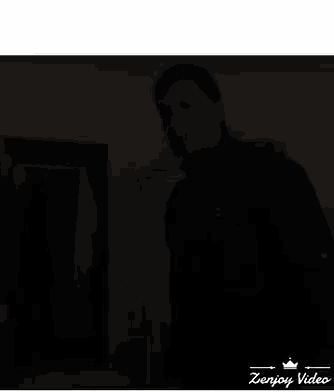 a man in a black shirt is standing in front of a closet with clothes hanging on it and the words zenjoy video below him
