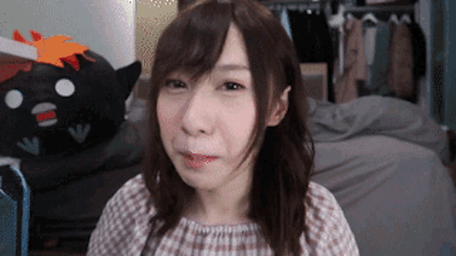 a woman is making a funny face in front of a stuffed animal ..