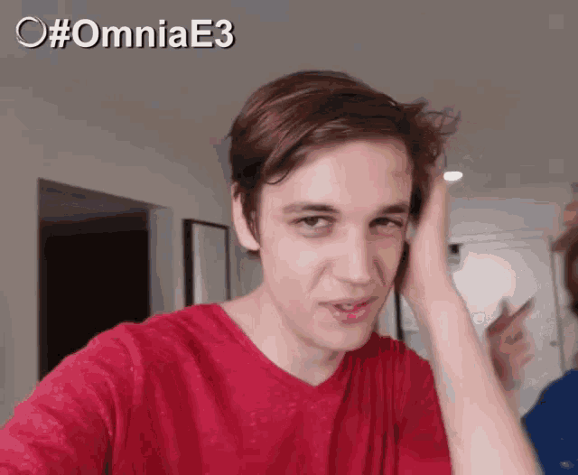 a young man in a red shirt is making a funny face with the hashtag #omniae3