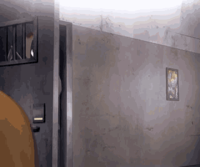 a person is standing in a prison cell with a picture on the wall behind them .
