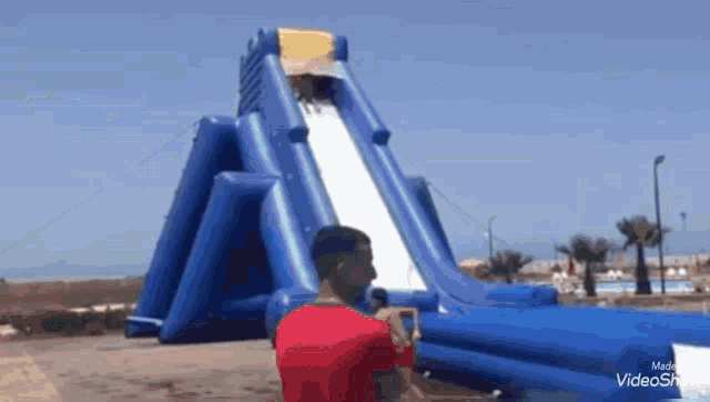 a man is taking a picture of an inflatable water slide .