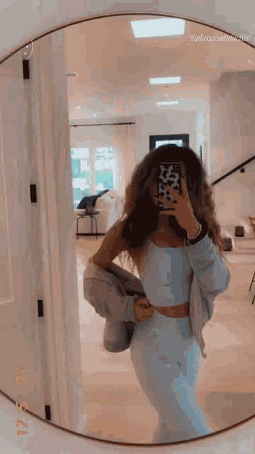 a woman taking a selfie in front of a mirror
