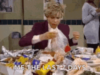 a woman is sitting at a table eating a sandwich and says `` me the last 7 days '' .