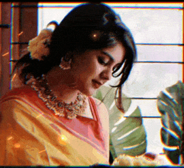 a woman wearing a necklace and earrings is looking down