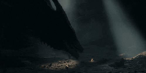 a light shines through a dark cave with a dragon in the background