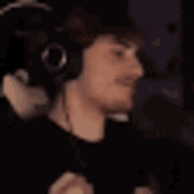 a blurry picture of a man wearing headphones and holding a microphone .