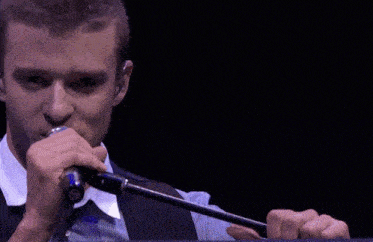 a man singing into a microphone while wearing earbuds
