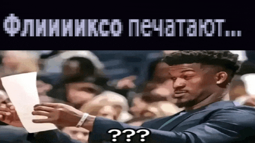 a man in a suit is holding a piece of paper in front of a crowd and says " ? " on the bottom