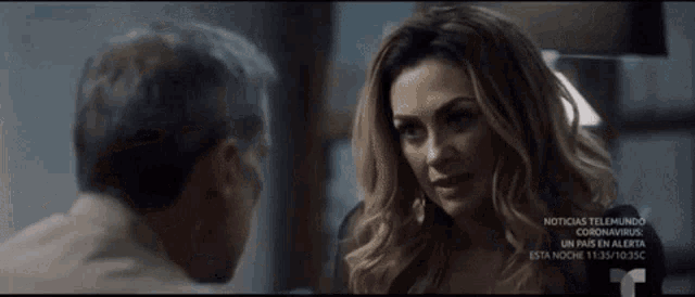 a man and a woman are looking at each other in a movie scene .