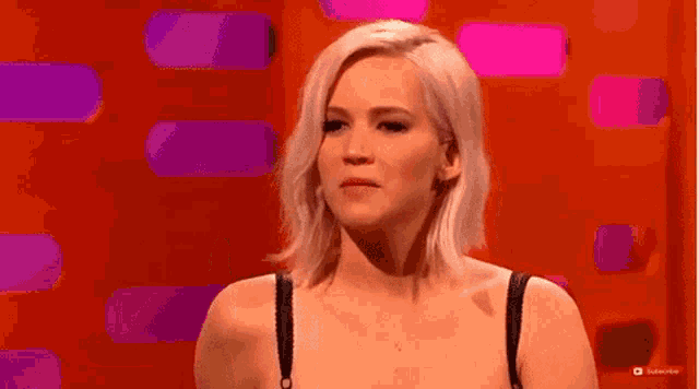 a woman is making a funny face while wearing a bra .
