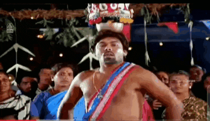 a shirtless man is dancing in front of a crowd .