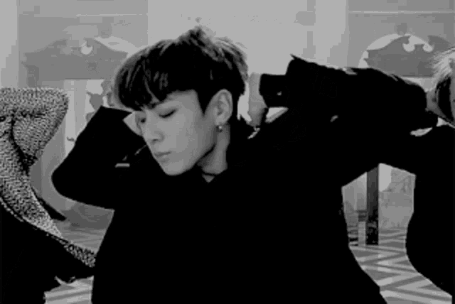 a black and white photo of a young man in a black jacket