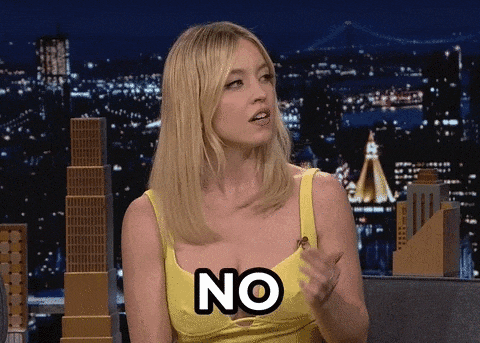 a woman in a yellow dress is saying no with her hand