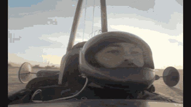 a man wearing a helmet is driving a car