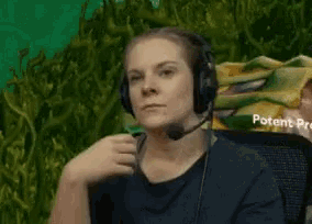 a woman wearing headphones and a microphone is sitting in front of a sign that says potent protein