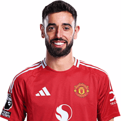 a man wearing a red manchester united jersey smiles for the camera