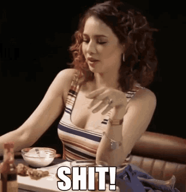 a woman in a striped tank top is sitting at a table with a bowl of food and says shit !