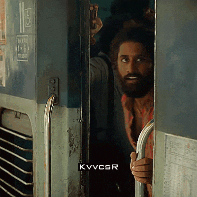 a man with a beard is peeking out from behind a door with kvvcsr written on the bottom