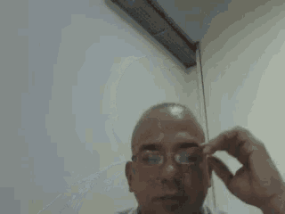 a bald man wearing glasses and a striped shirt