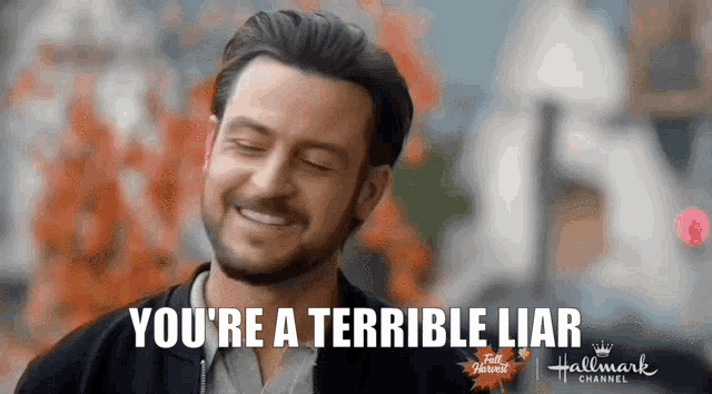 a man with a beard is smiling and says you 're a terrible liar