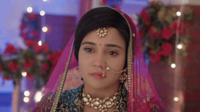 a close up of a woman wearing a veil and nose ring .