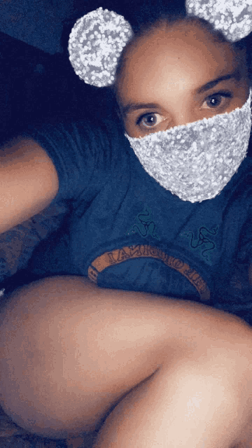 a woman wearing a mask and a t-shirt that says razer on it