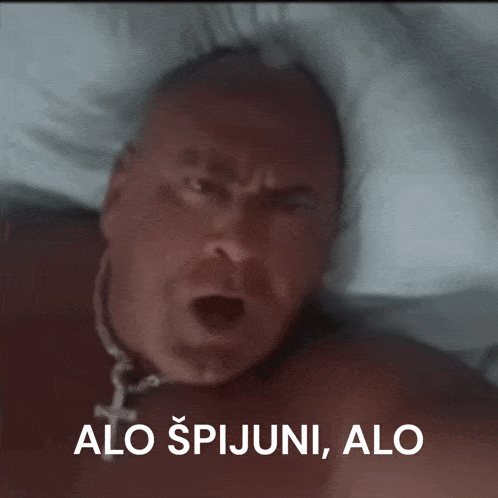 a man laying on a bed with the words " alo spijuni " on the bottom right