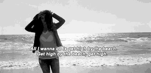a black and white photo of a woman standing on the beach with a quote .