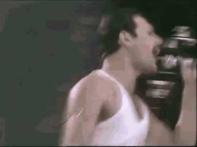 a close up of a man singing into a microphone .