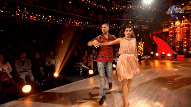 a man and a woman are dancing on a stage that says dancing brasil on it