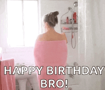 a woman wrapped in a pink towel is standing in a shower and saying `` happy birthday bro '' .