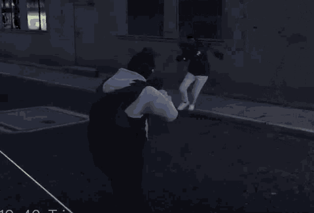 a man in a black hoodie is holding a lighter in his hand