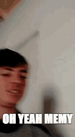 a blurry picture of a young man with the words oh yeah memy written on it .