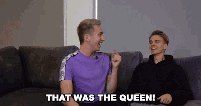 two men are sitting on a couch and one of them is pointing at the other and says that was the queen