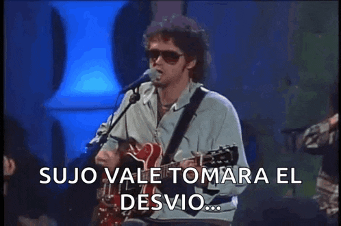 a man singing into a microphone while playing a guitar