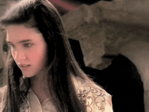 a woman with long hair is wearing a white shirt with a floral pattern on the sleeves .