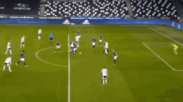 a group of soccer players are playing on a soccer field with a goalie .