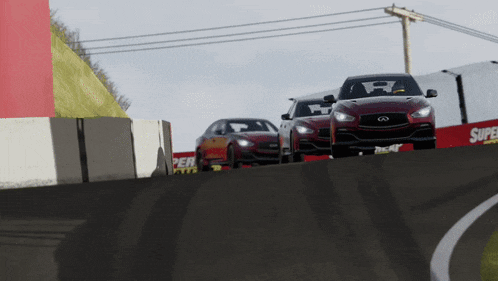 three cars are driving down a race track with a super tires sign in the background
