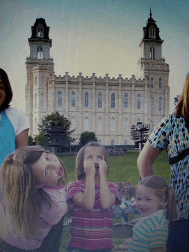 a group of young girls are standing in front of a large building