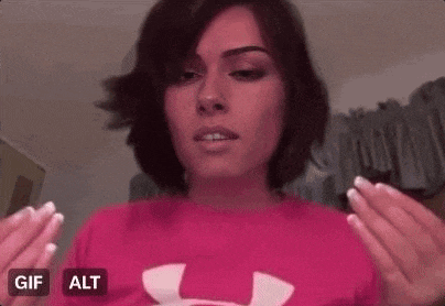 a woman in a pink under armour shirt is making a face .