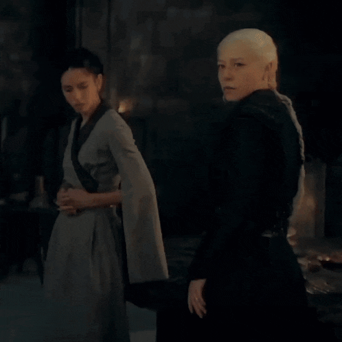 a couple of women standing next to each other in a dark room