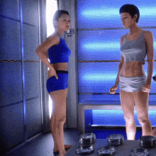 two women standing next to each other in a room with blue lights