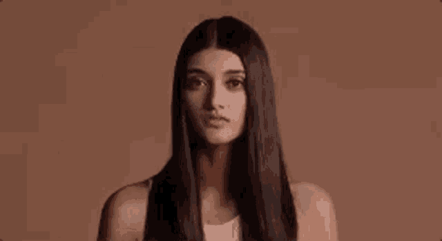 a woman with long hair is making a funny face .