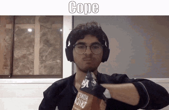 a man wearing headphones and glasses is holding a bag of chips with the word cope above him