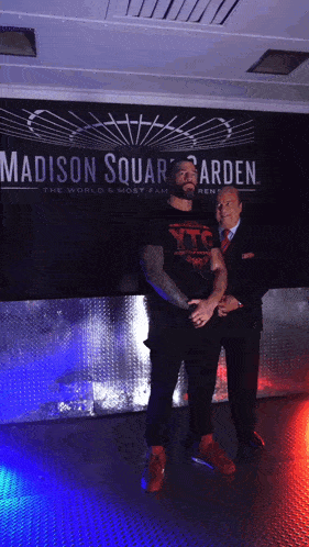 two men standing in front of a madison square garden sign