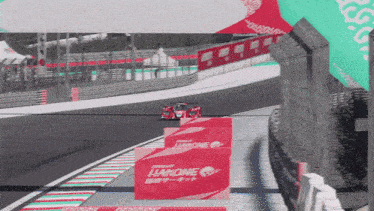 a race car is driving down a track with a sign that says hakone on it