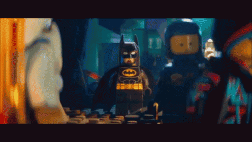 a lego batman standing next to a lego ninjago character