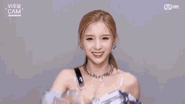a woman wearing a blue and white dress is dancing in front of a mnet logo